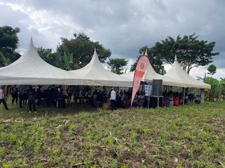 A large group of attendees under a tent