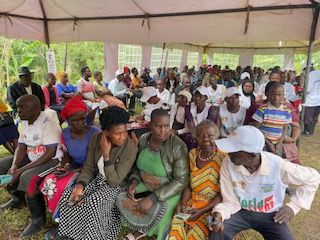 Very large group of people waiting under a tent